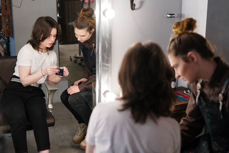 Stylist colouring a client's hair in a busy Auckland beauty salon