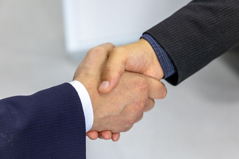 Handshake sealing a commercial insurance agreement in an Auckland office
