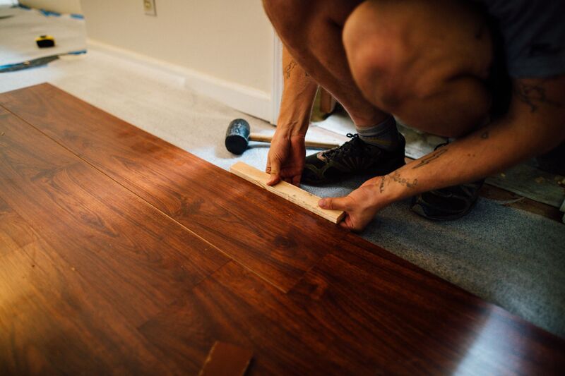 Contractor installing wood flooring in an Auckland home renovation