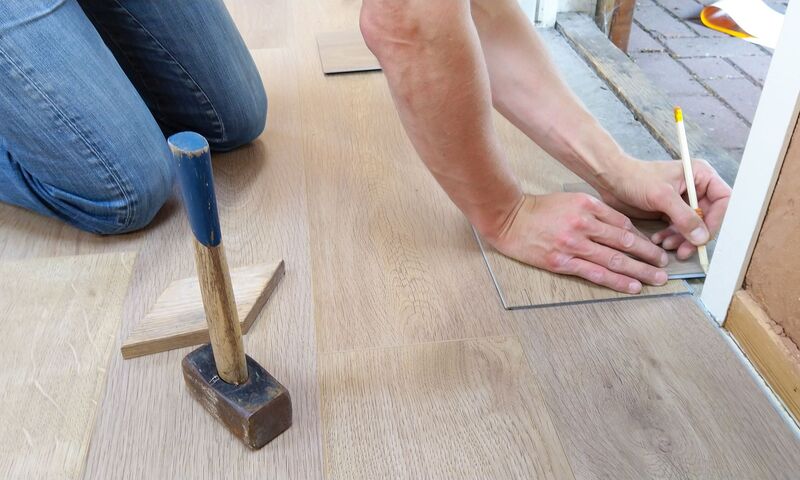 Installer laying timber floorboards on an Auckland flooring job