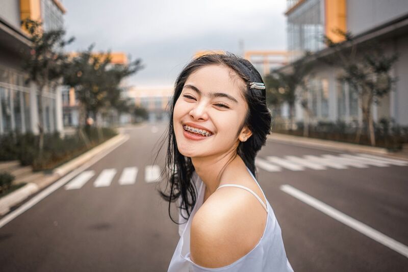 Patient with dental braces smiling after orthodontic treatment in Auckland