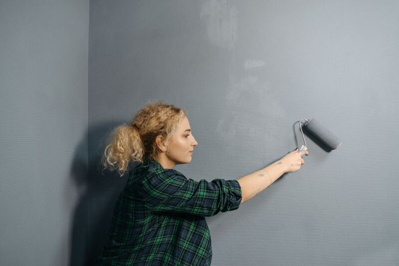 Painter rolling fresh paint onto an interior wall in an Auckland home