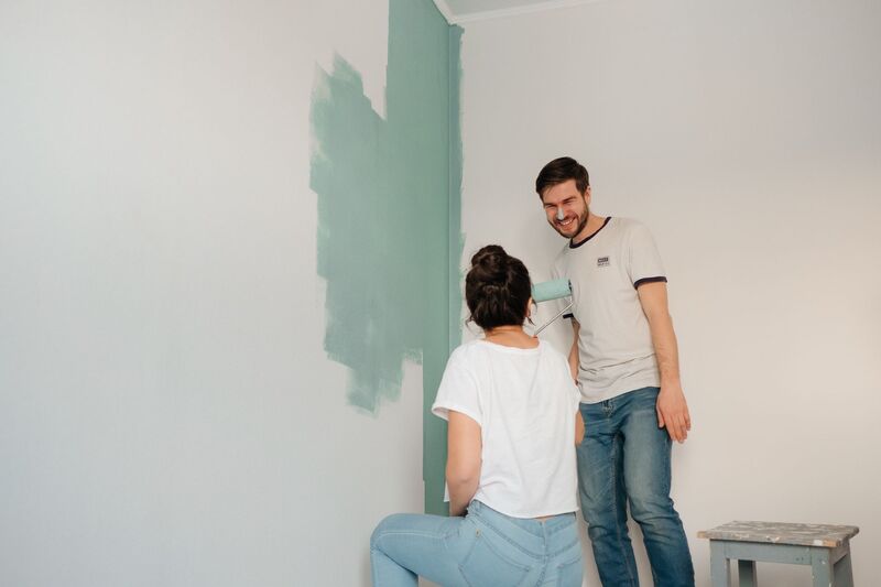 Close-up of a painter applying a smooth coat of wall paint on an Auckland project