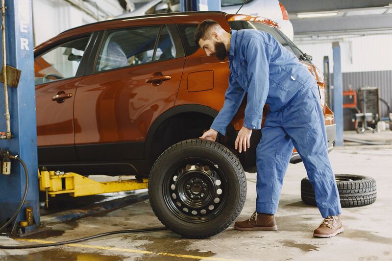 Technician fitting a new tyre onto a wheel at an Auckland fitting bay